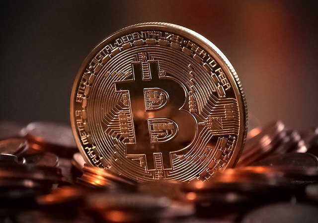 Bitcoin piece on top of coins